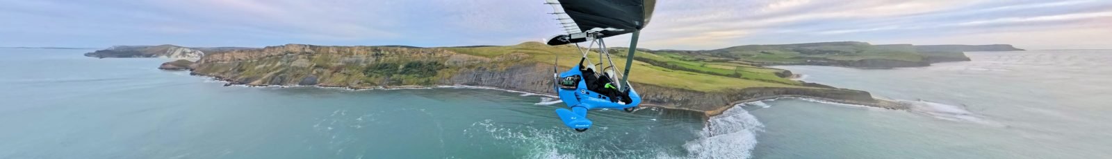 A DeltaJet 500 Stingray microlight flying over the Jurassic Coast in the UK